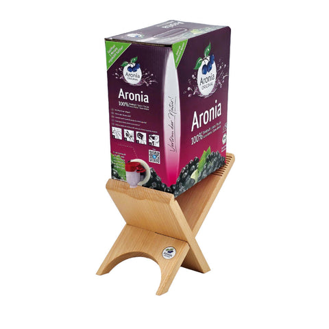 Aronia-Direktsaft Bag-in-Box auf Holzständer, lila Verpackung mit roter Zapfhahn-Tülle.