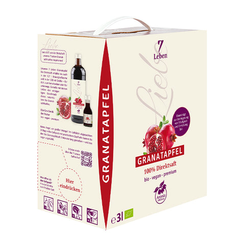 Bag-in-Box 3 Liter "7 Leben" Granatapfel-Direktsaft mit zwei Flaschen davor und aufgeschnittenen Granatäpfeln